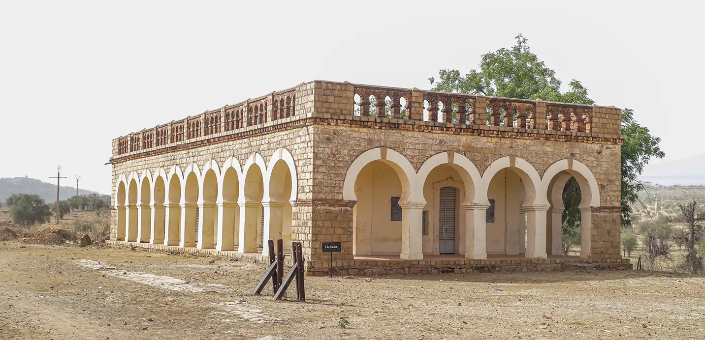 Bâtiment historique en pierre à arcades et balustrade, dans la région de Kayes